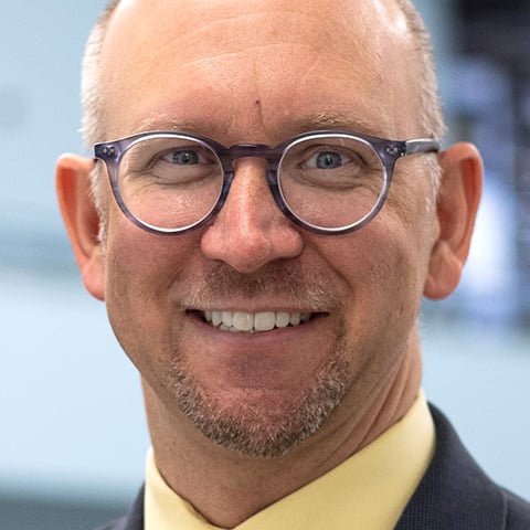 Smiling man wearing glasses in a professional headshot