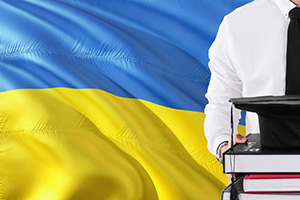 Student from the Ukraine in front of blue and yellow flag.