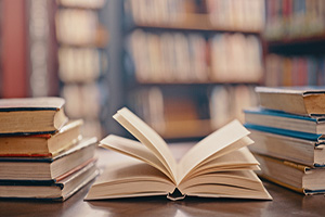 Image of an open book in a library.