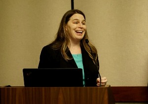 Female speaking from behind a wooden podium.