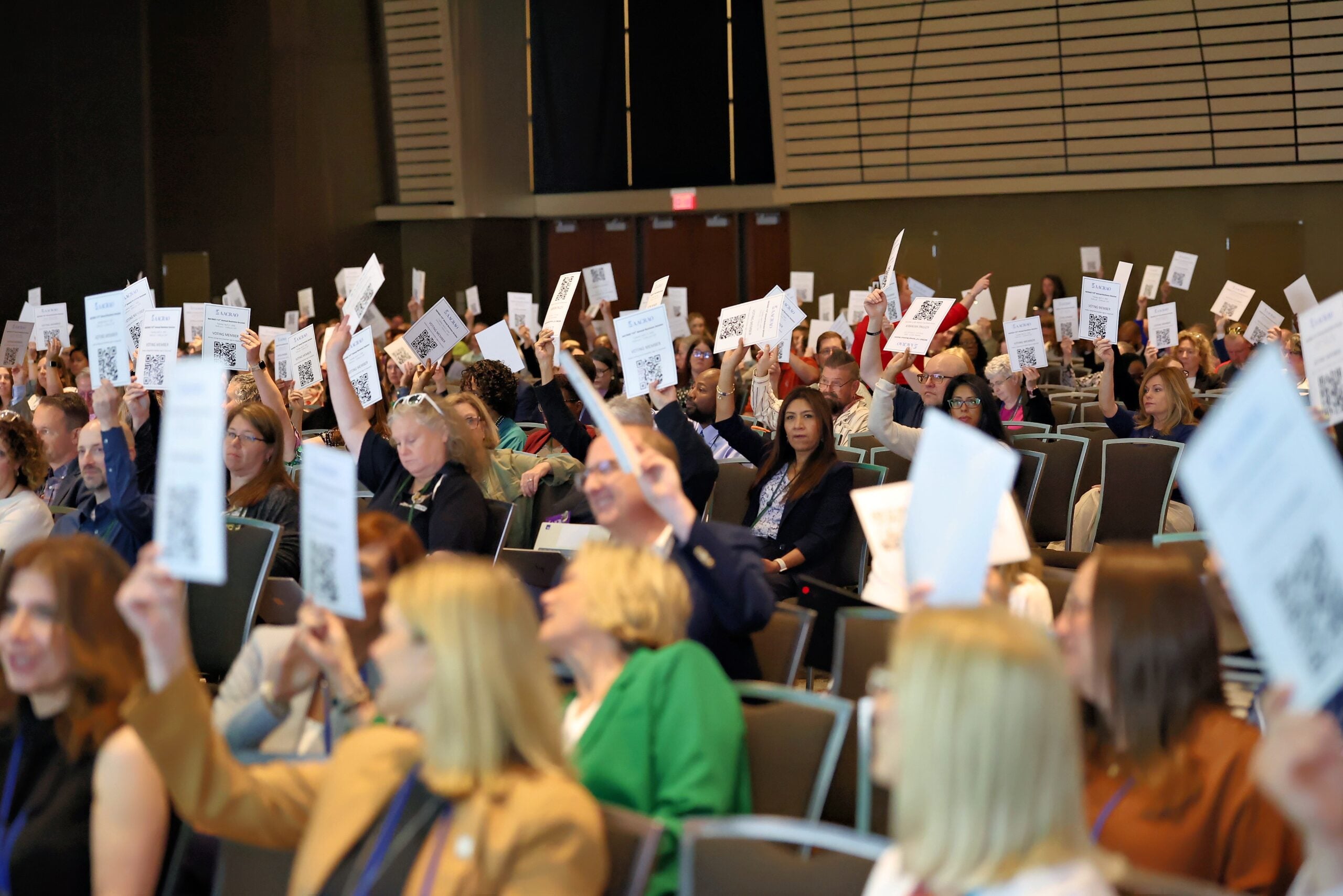 AACRAO members voting by using paper cards in a ballroom