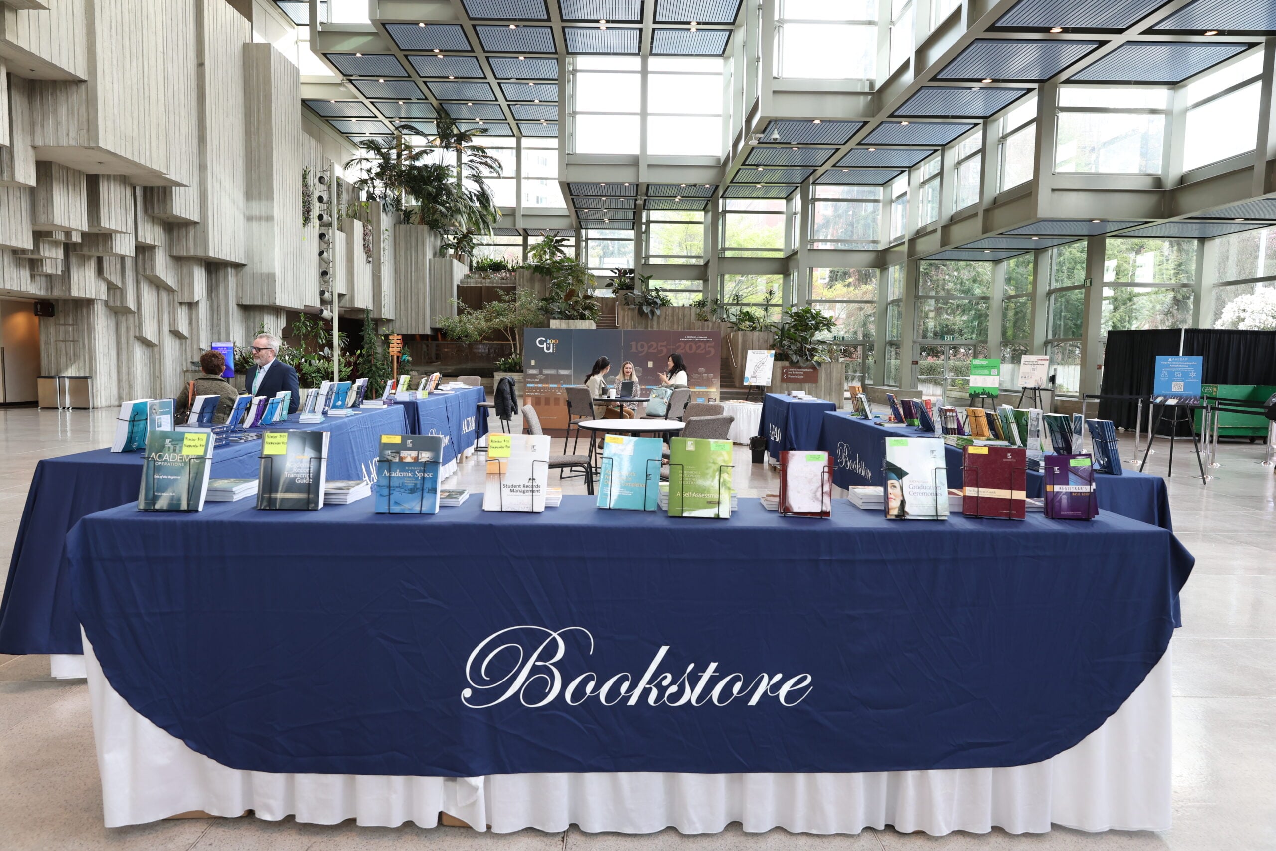 Tables with AACRAO books displayed in an atrium