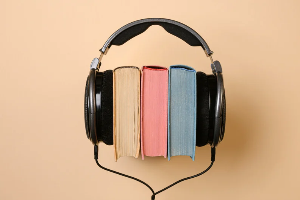A pair of headphones around three books